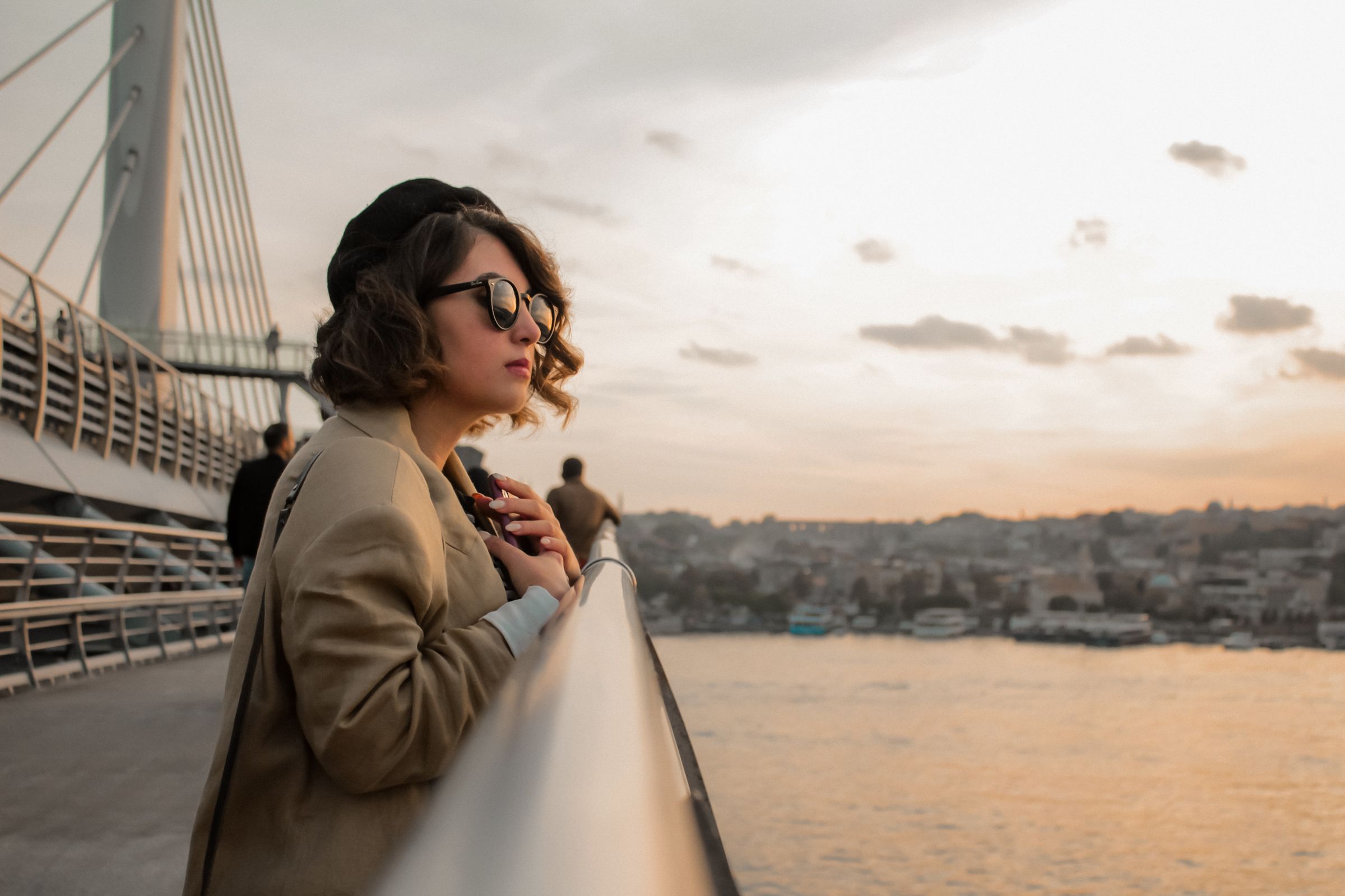 Golden hour terasında gün batımında Smiles gözlükleri — sıcak amber ve şeftali tonlarında Akdeniz ışığı